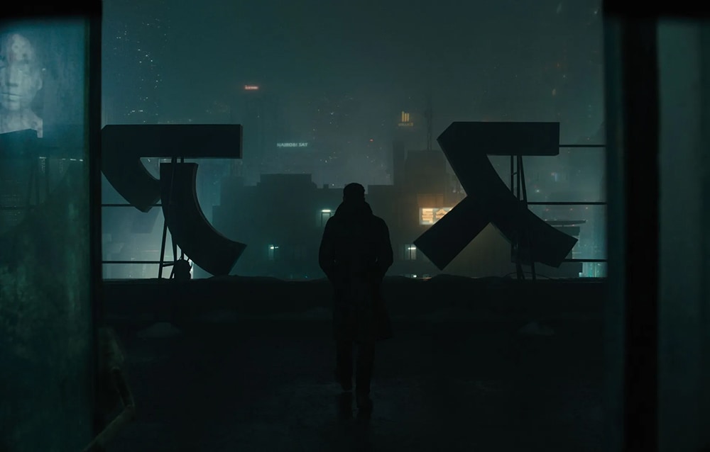 Silhueta de K em Blade Runner 2049 a olhar a cidade de um telhado, simbolizando a arquitetura de conhecimento para agentes de IA